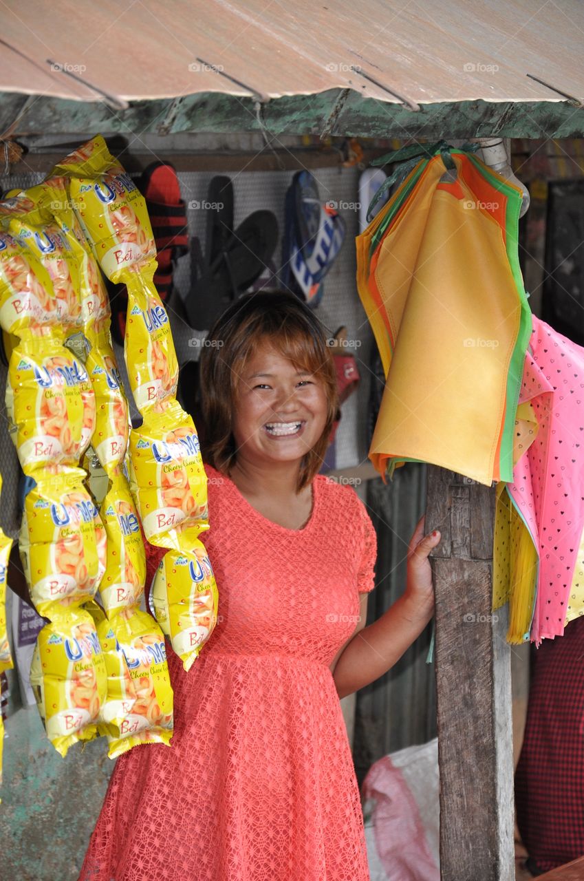 young smiling nepalese woman selling products in a small shop not far from kathmandu