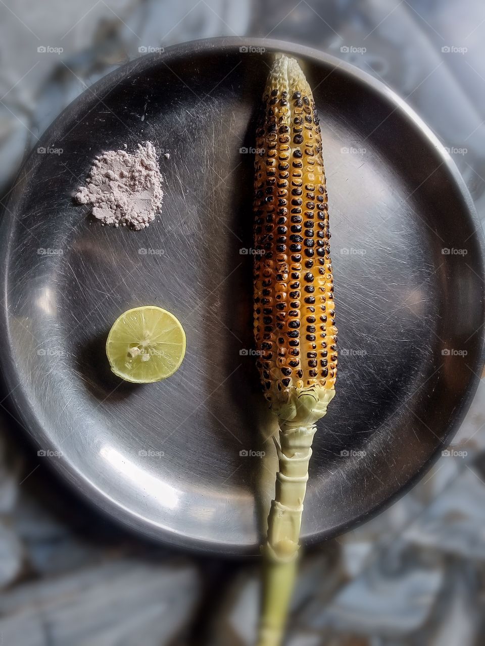 Fresh organic roasted corn served in a plate with lemon and salt