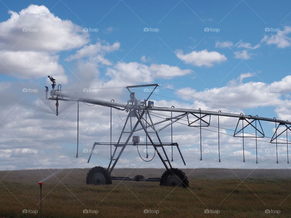 The end of a pivot line irrigating farmland in Central Oregon on a sunny summer day. 