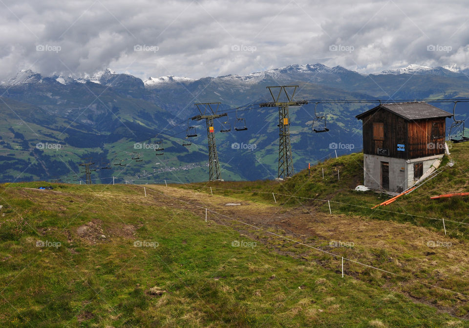 Cable lift in Swiss mountains. photo taken during summer holiday in Switzerland.  cable lift and typical Swiss house. 