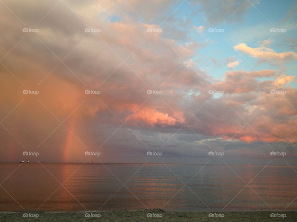 The rainbow in the clouds during the sunset over the Baltic sea oh Poland 