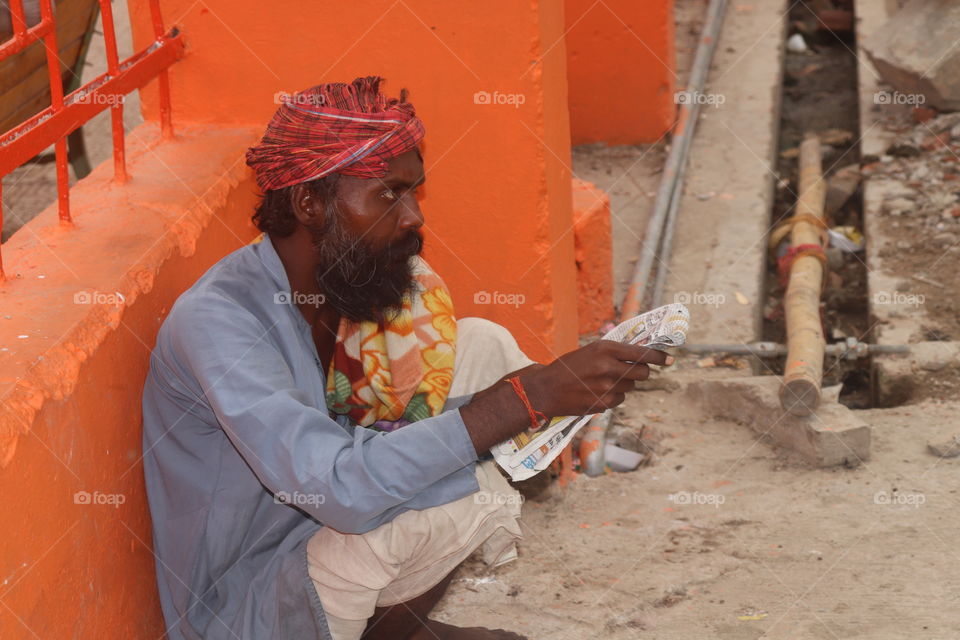 a old man reading pepar in allahabad sangam india.