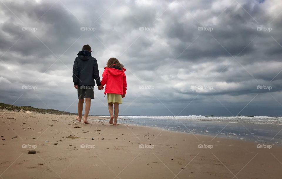 Hand in hand at the beach on a windy afternoon