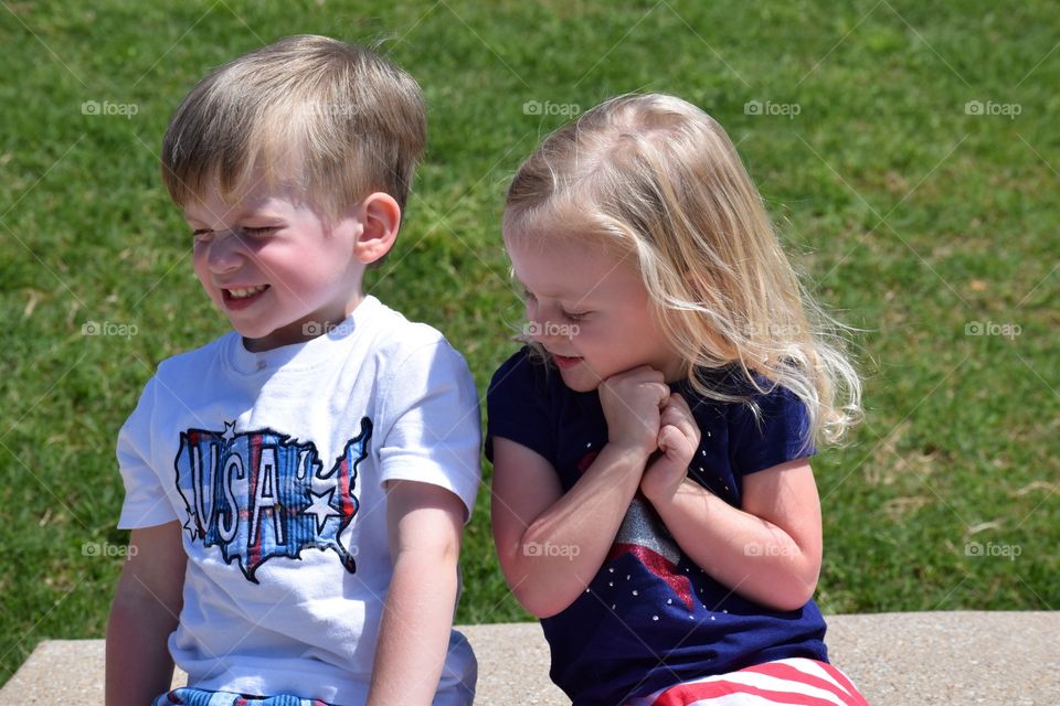 Cute little boy and girl sitting side by side