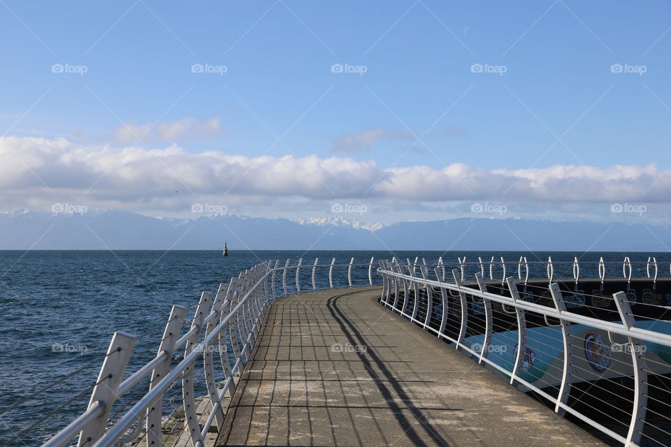 Shadow of metallic fence on breakwater 