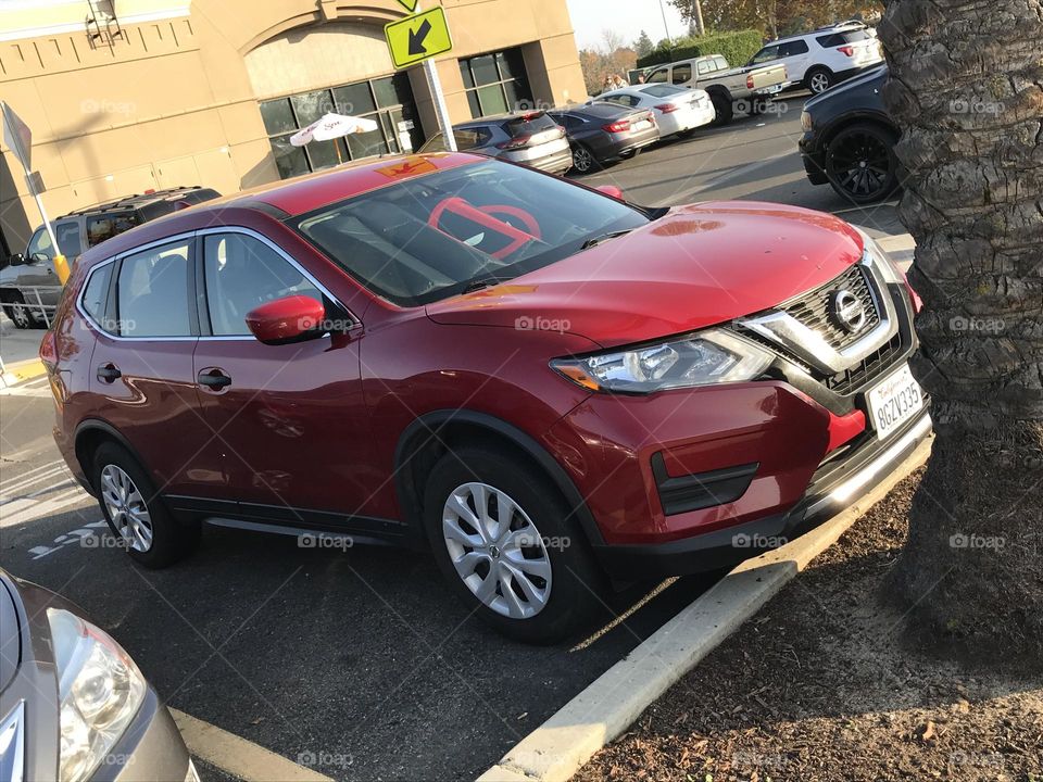 A red vehicle in the parking lot.