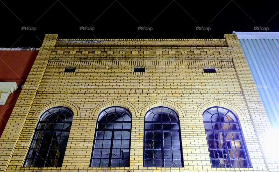 Arched windows set in blond brick facade 