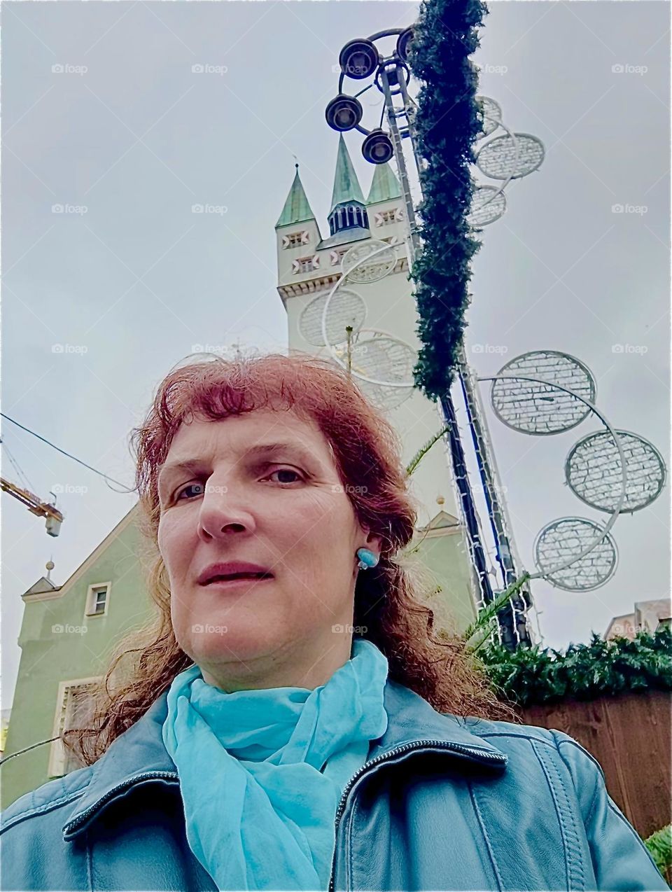 This lady is on the „Theresienplatz“, one of two main squares in the center of „Straubing“ in „Niederbayern“ or „Lower Bavaria“. Note the medieval tower and decorations for the „Christkindlmarkt“, an annual Christmas fair. 2023. Hypnotic Productions