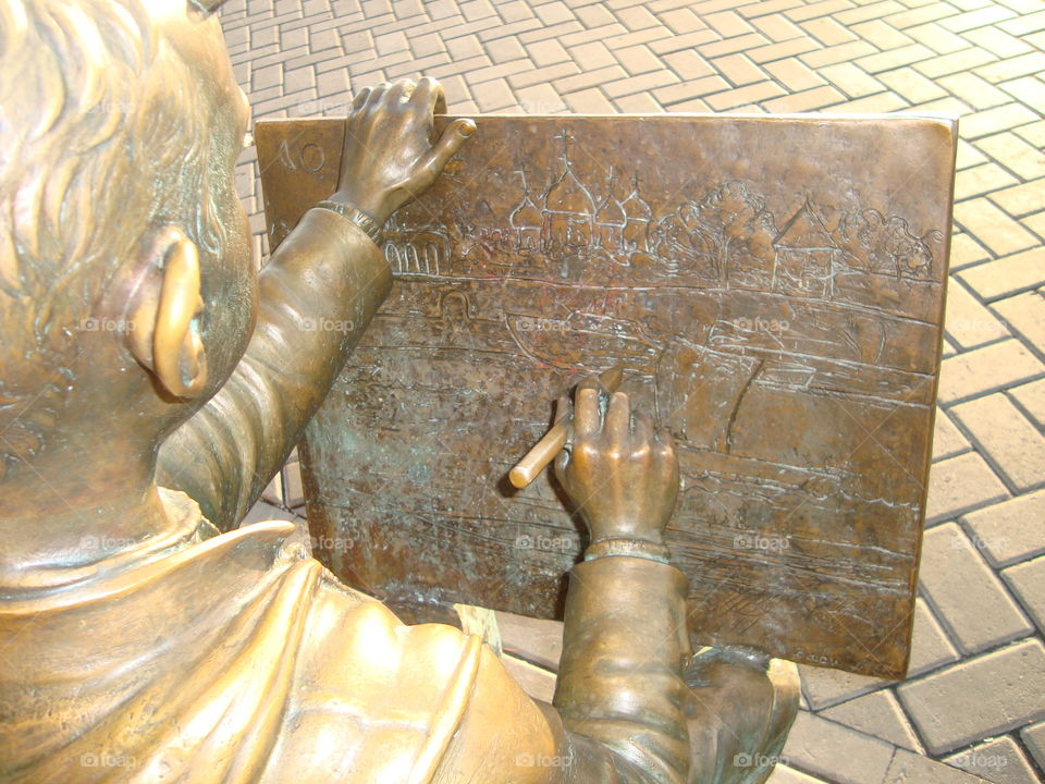 Sculpture. Boy draws picture