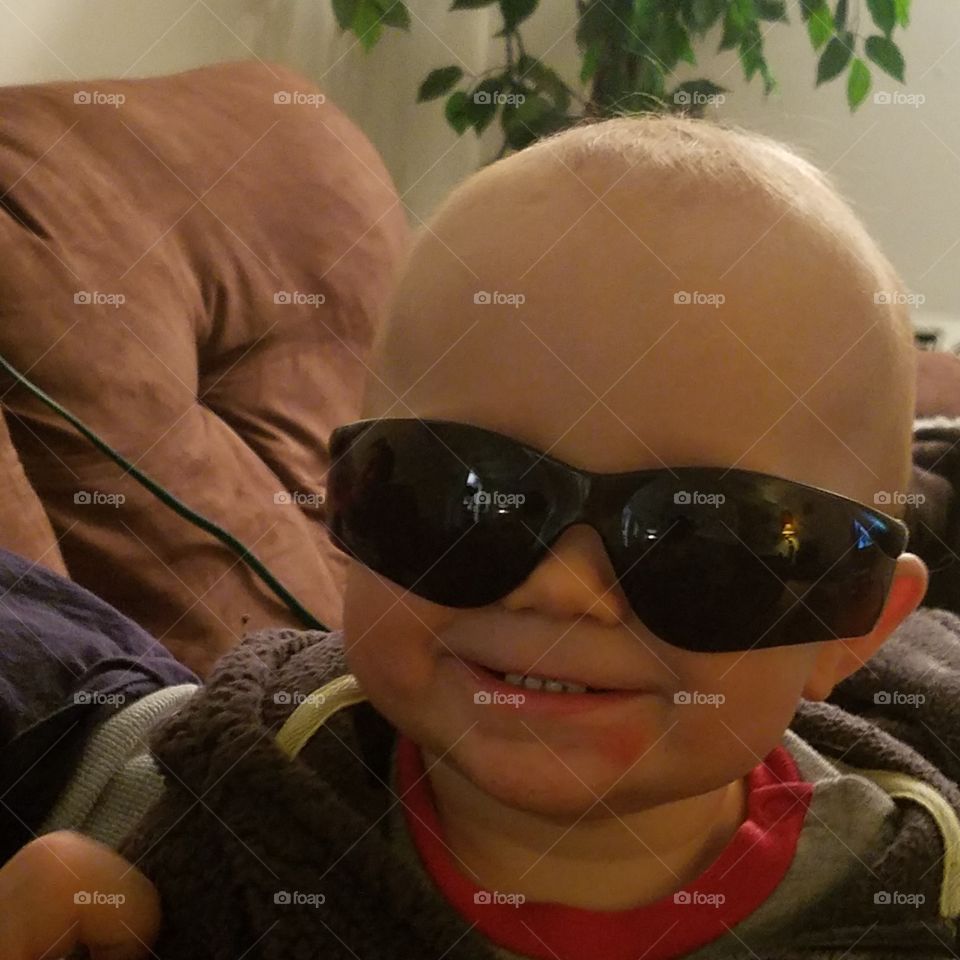 A little boy with black sunglasses