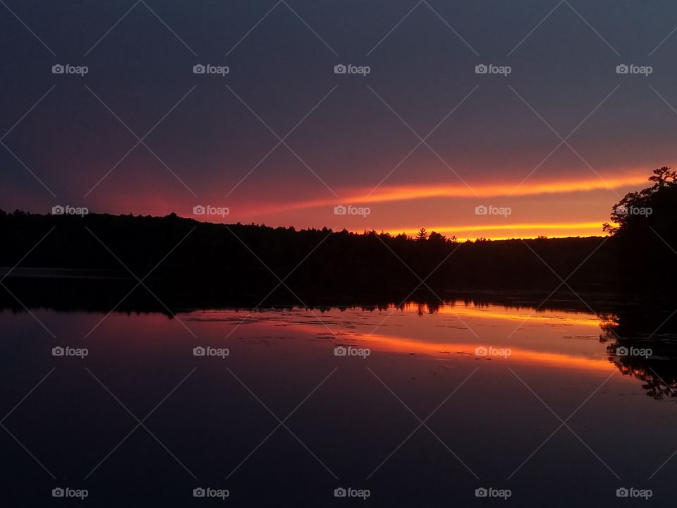 Scenic view of lake against sky at sunset