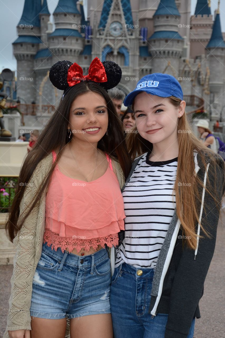 Portrait of a two girl background of Disney castle