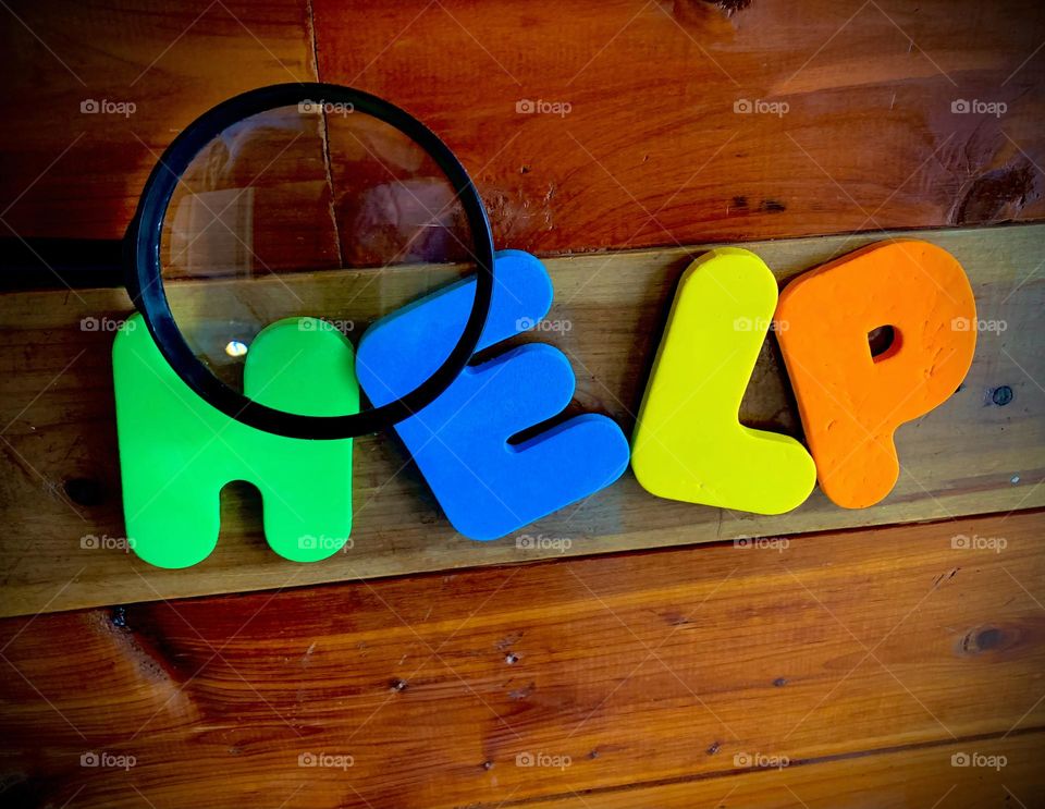 The Word HELP Written On Wooden Wall Background With Magnified Top Two Letters, Call