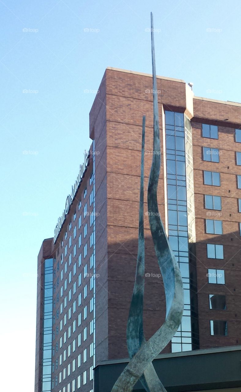 Metal Against Brick & Glass Backdrop. Sculpture 