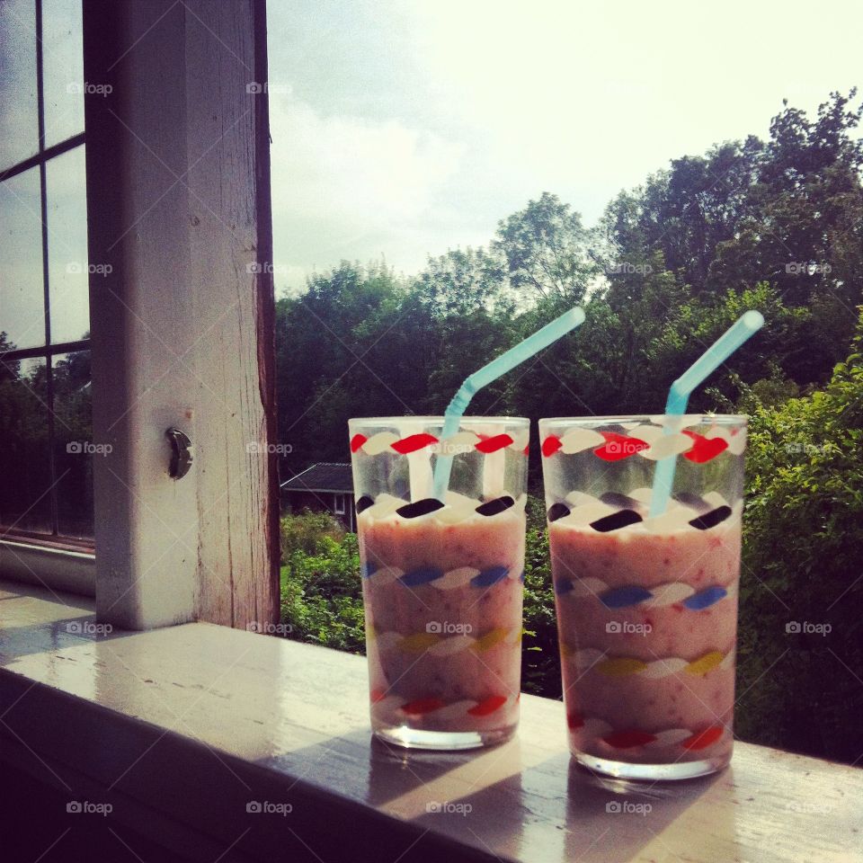 Smoothie glasses with straws in window