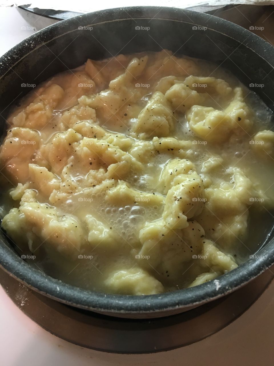 Rivet noodles boiling in broth in pan 