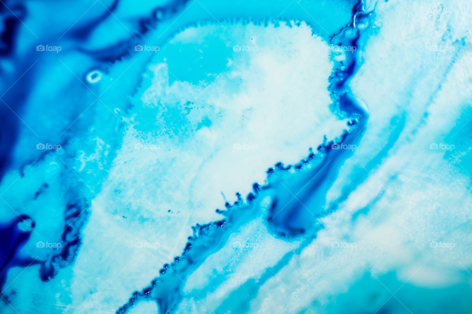 The ink to refill the printer cartridge was spilled onto the white washbasin and the paints blended into abstract drips and patterns.