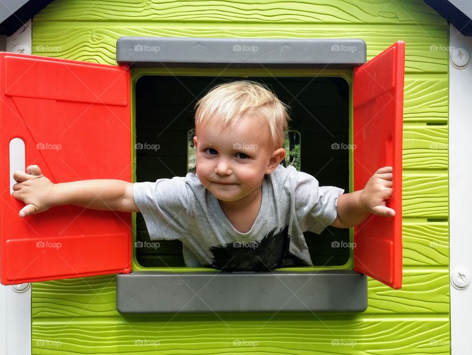Boy looking out from playhouse window