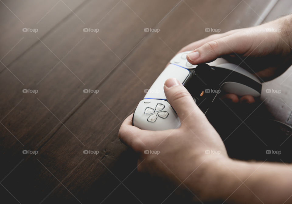 Pair of male hands holding a games controller and playing video games with copy space