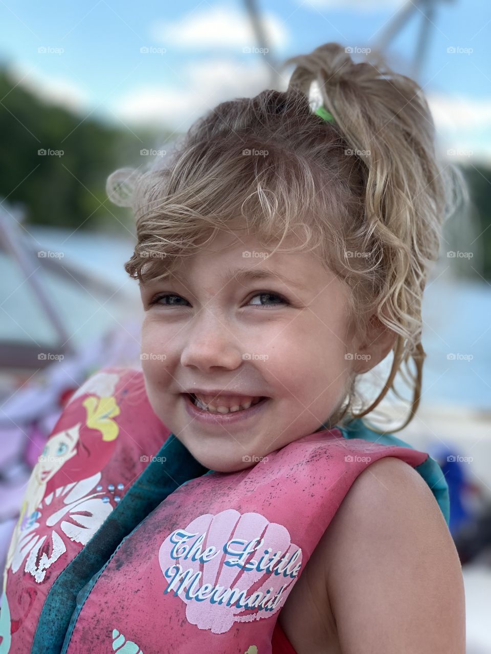 A happy, smiling girl having summer fun on a boat 