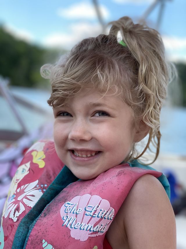 A happy, smiling girl having summer fun on a boat 