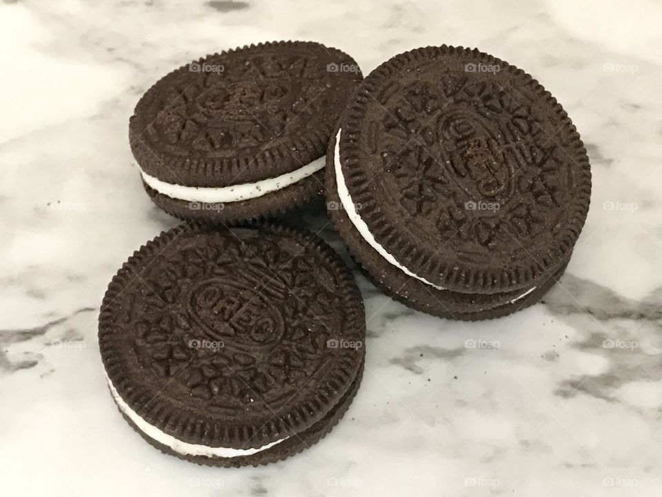 A pile of chocolate double stuffed Oreo cookies on a  marble background