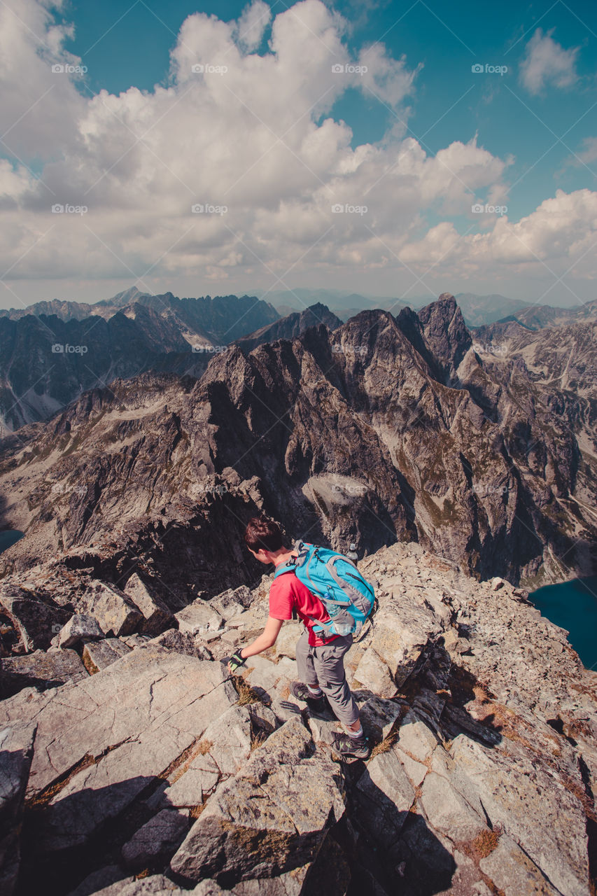 Teenage boy climbing on rocky mountain