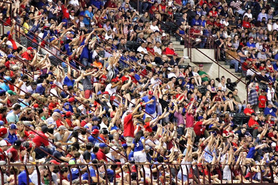 Entertaining the crowd. Crowd doing the wave at a Texas Rangers baseball game