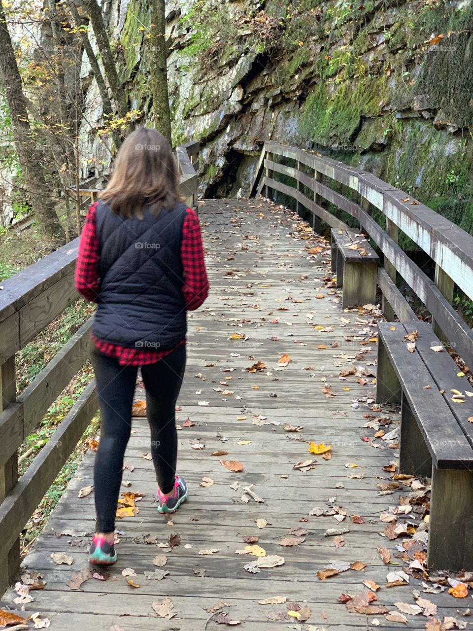 Woman walks on a boardwalk in the morning.