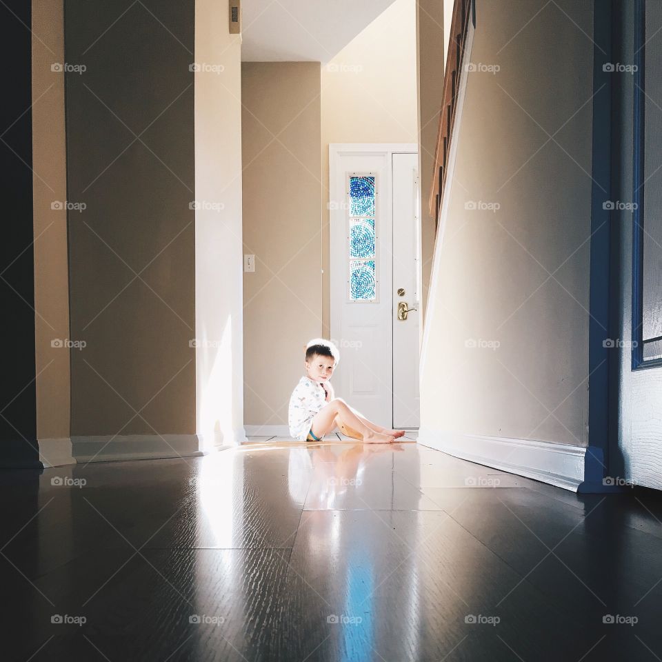 Reflection of boy on tile floor at home