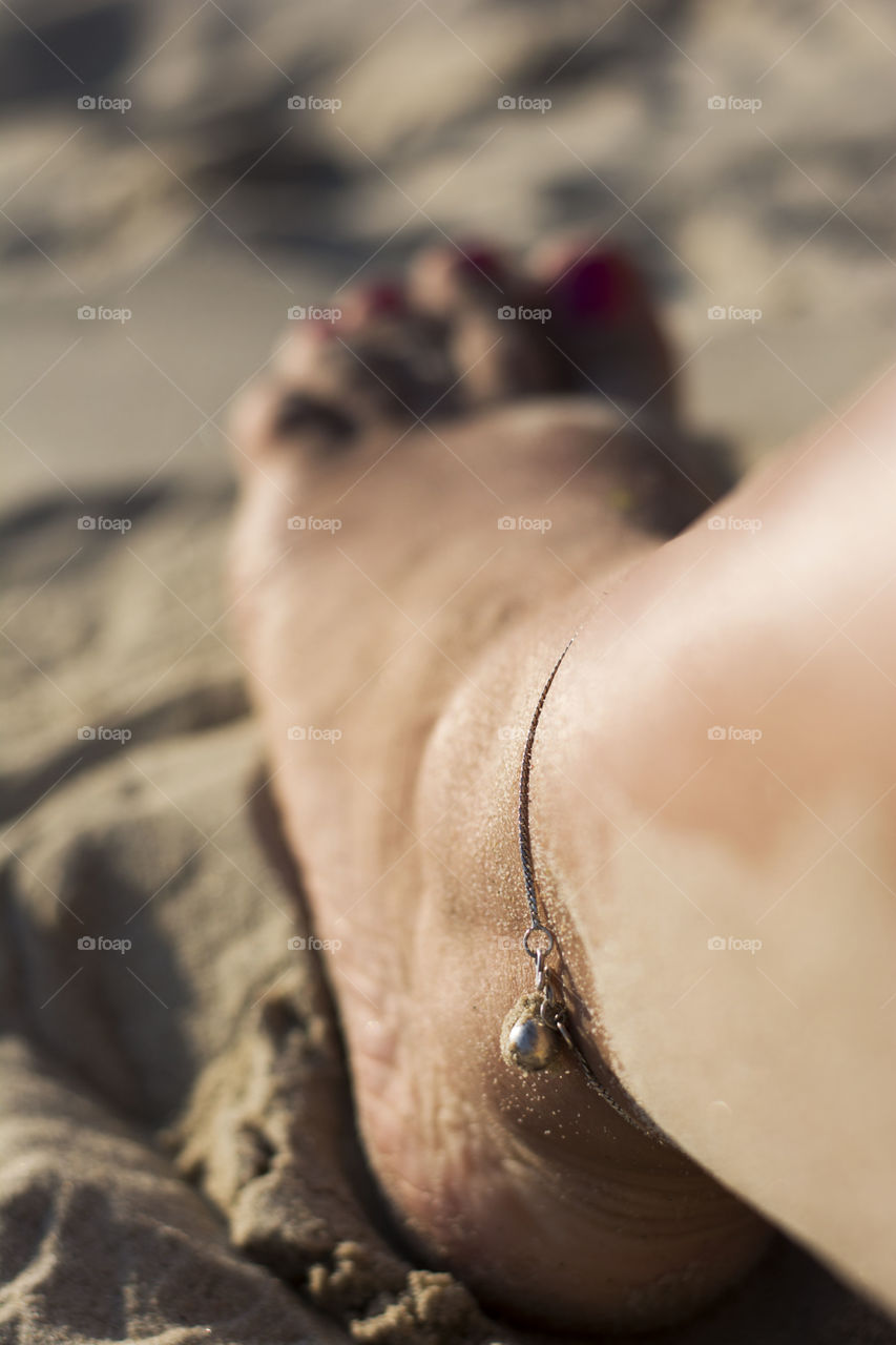 feet with bracelet. feet with bracelet on the beach