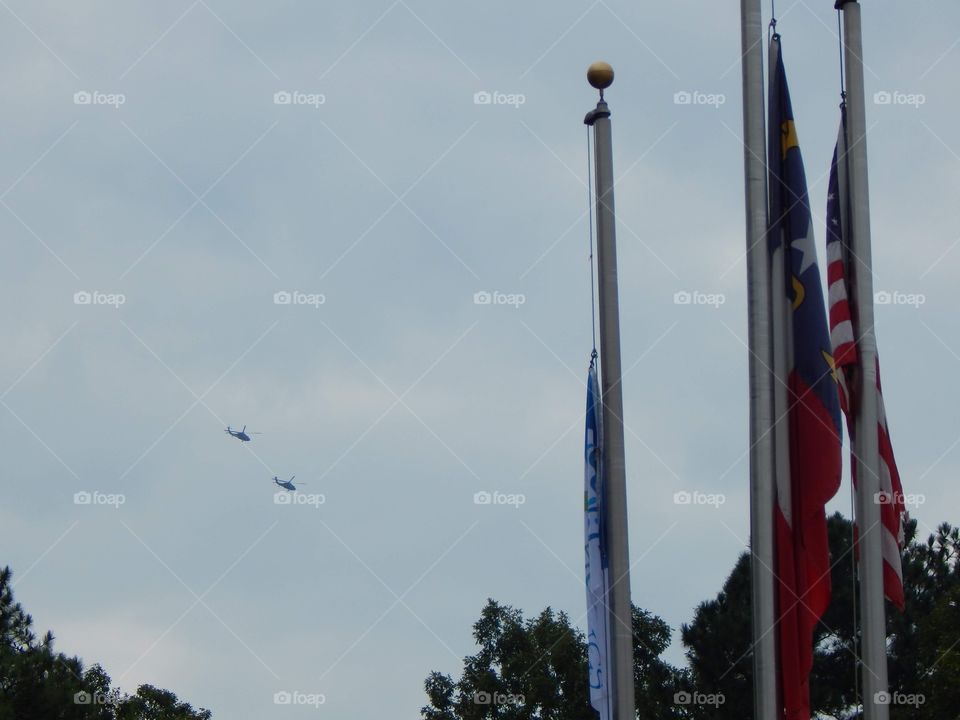 Flagpoles with Helicopters in the Background 