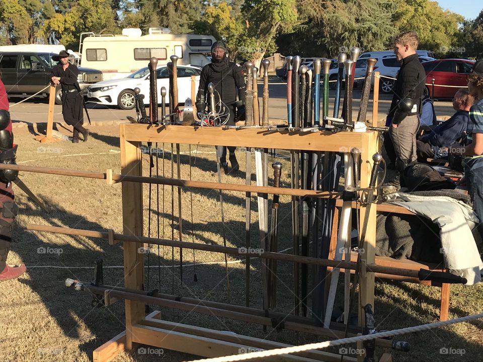 An array of battlefield swords on the display rack at the encampment of Iron Gate Martial Arts during the Kearney Park Renaissance Faire.