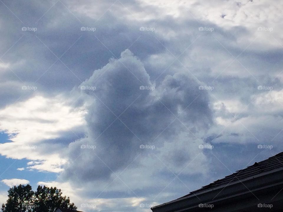 Heart of clouds coming out of stormy sky
