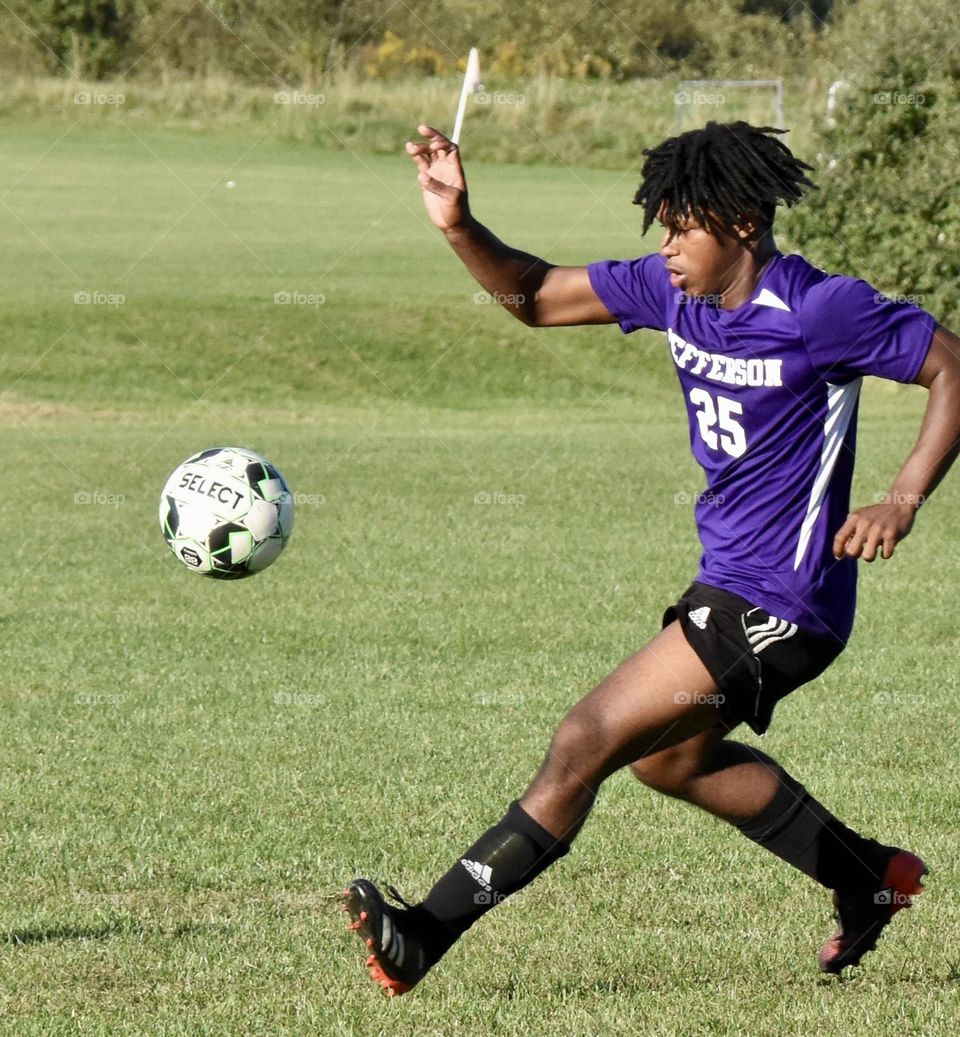 Young man running and getting ready to kick a soccer ball