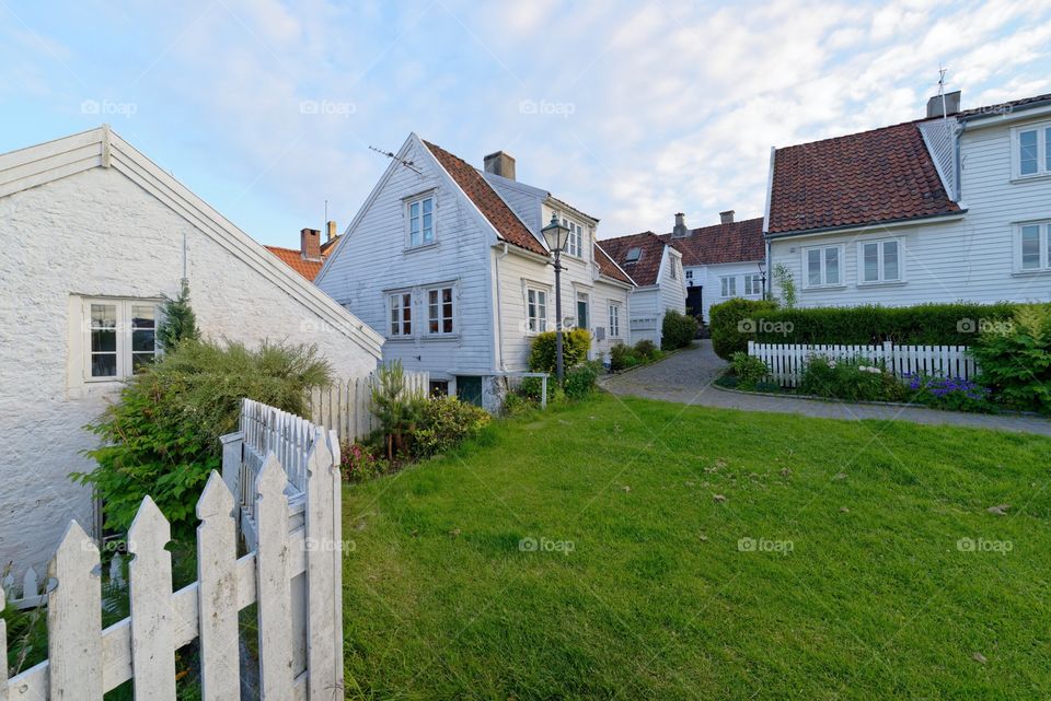With houses in Old Stavanger . Little green space in front of the white houses in the old part of Stavanger , Norway 