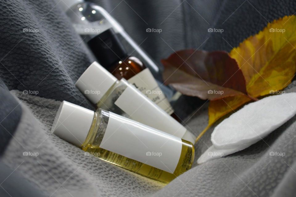 Jars with cream, shampoo and cosmetics on a background with autumn leaves