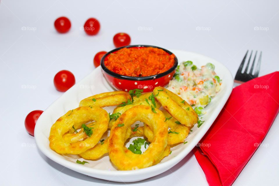 Fried onion rings with paprika sauce and vegetables