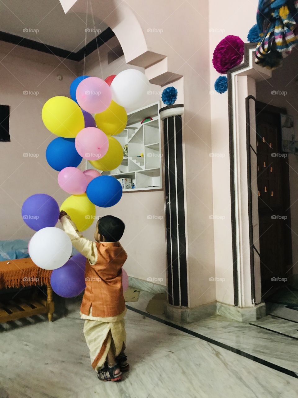 Boy playing with colour full balloons