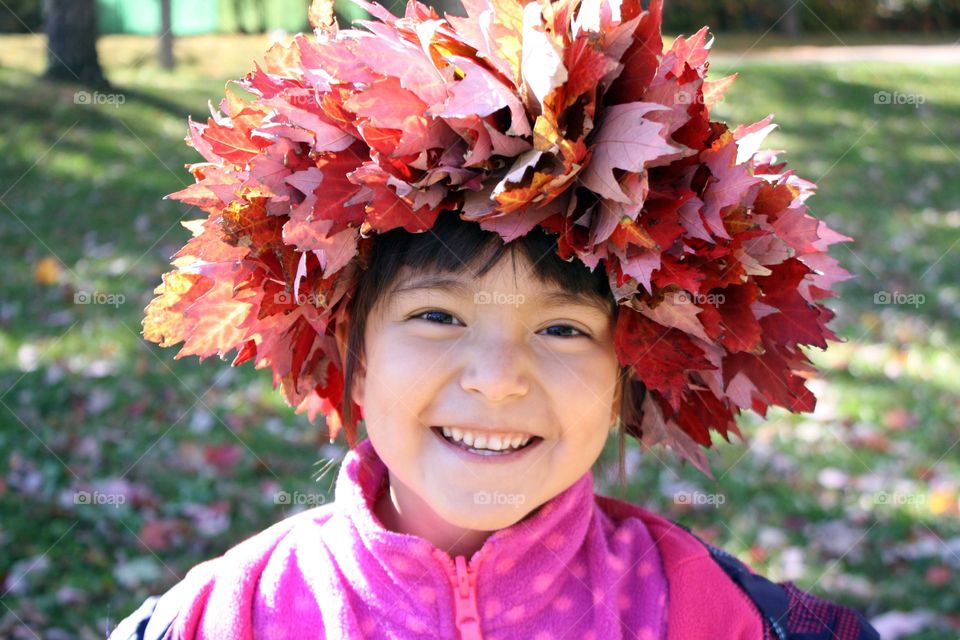 Happy girl in an autumn leaves wreath