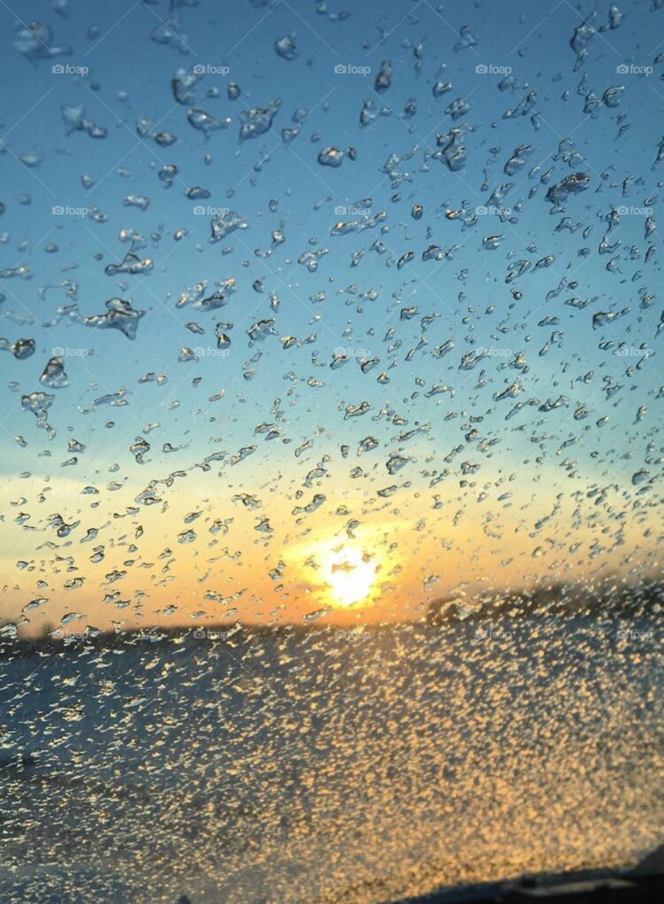 A blurred sunrise shining through a frost covered window