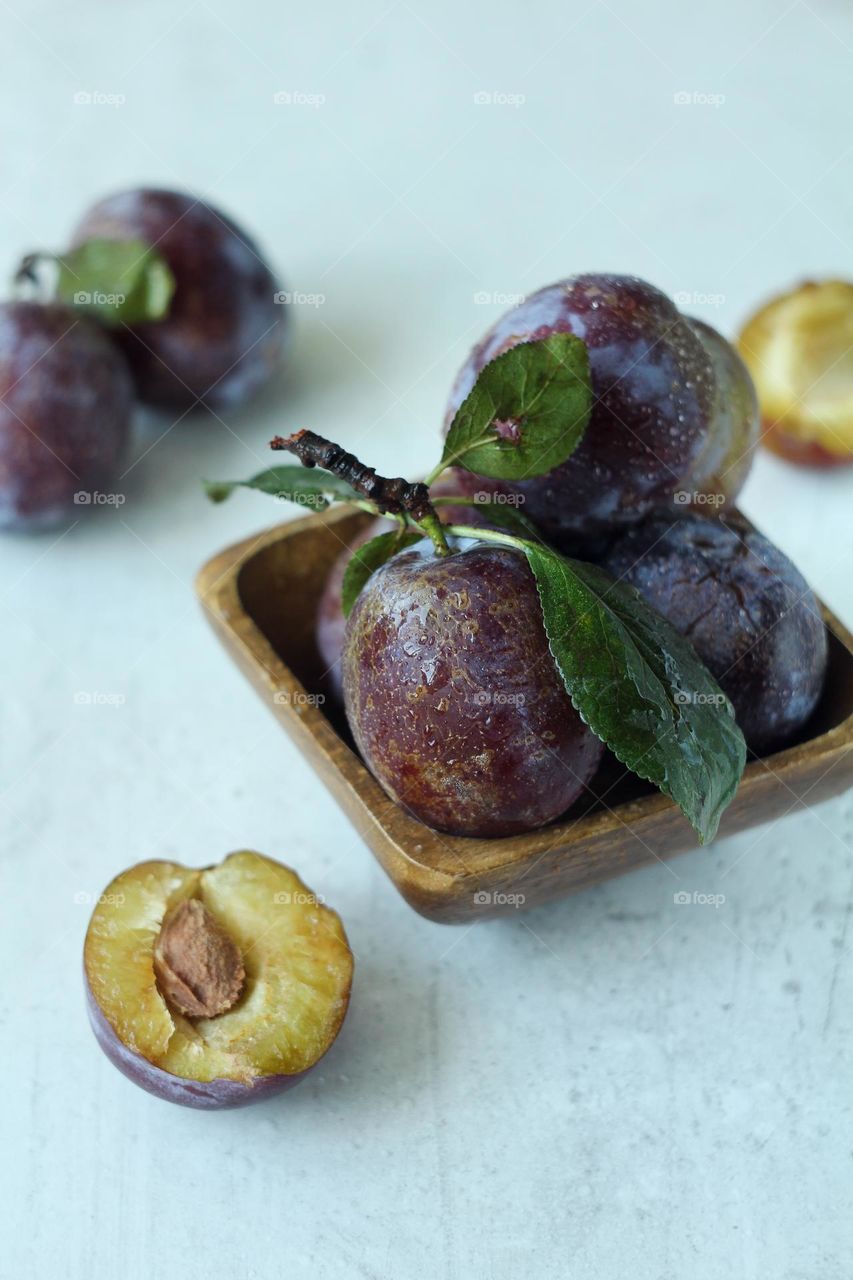 Fresh plum in a wooden vase