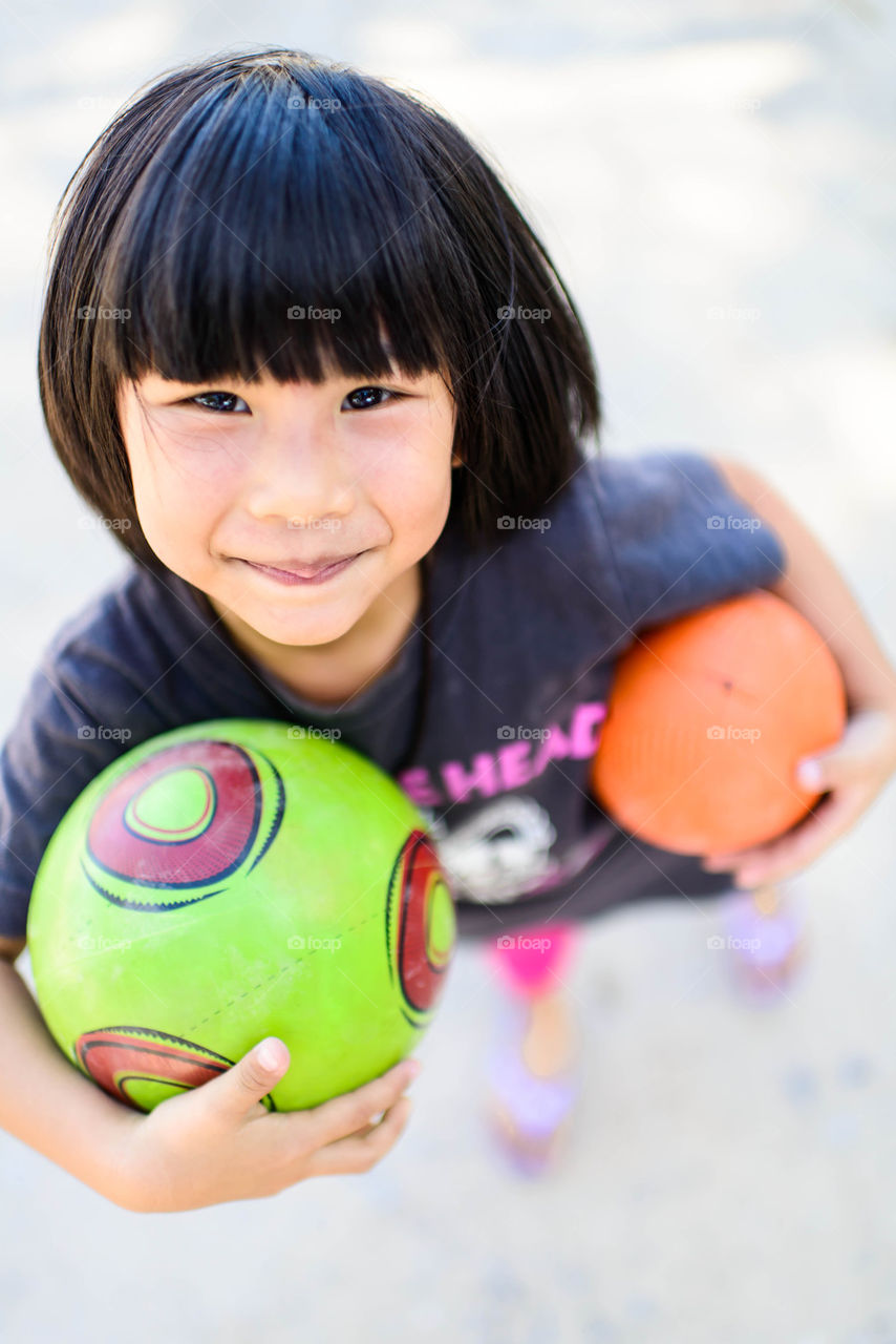 Smiling Asian girl and balls.