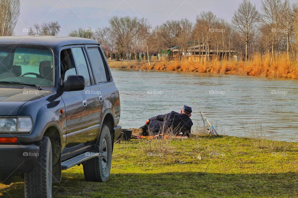 a man came by car to the river to go fishing.