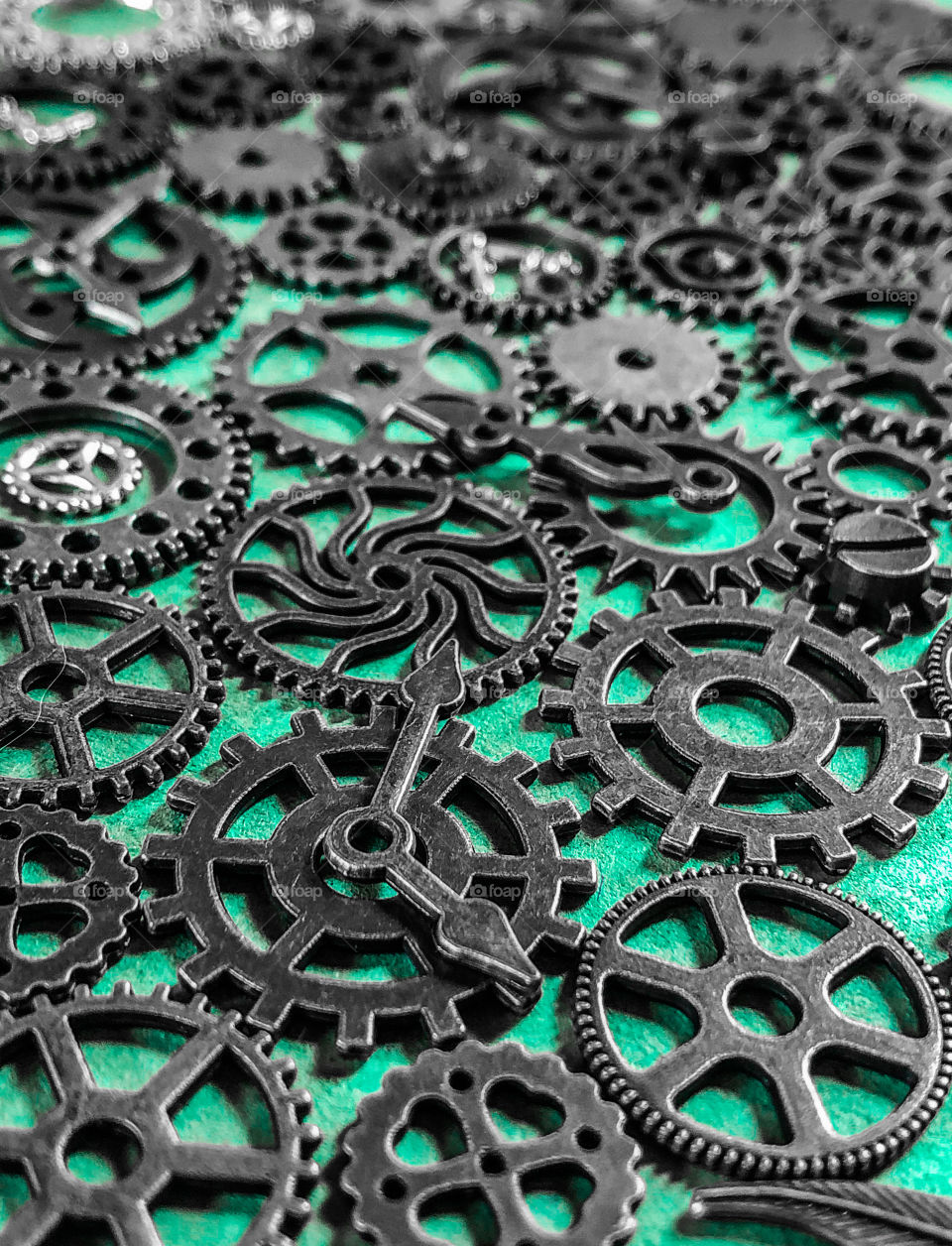 Gunmetal grey cogs and gears on a green background 