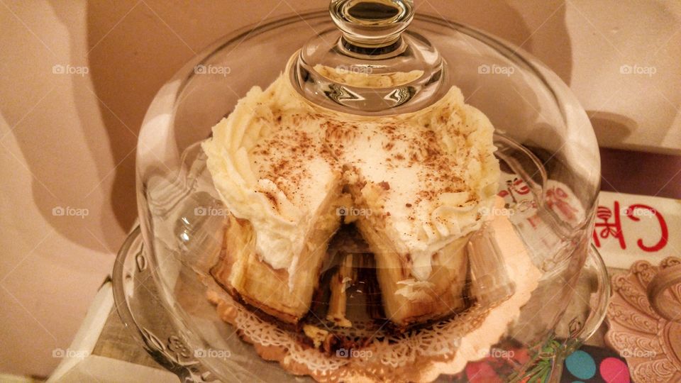 Eggnog cheesecake with a chocolate chip cookie base in a glass case.