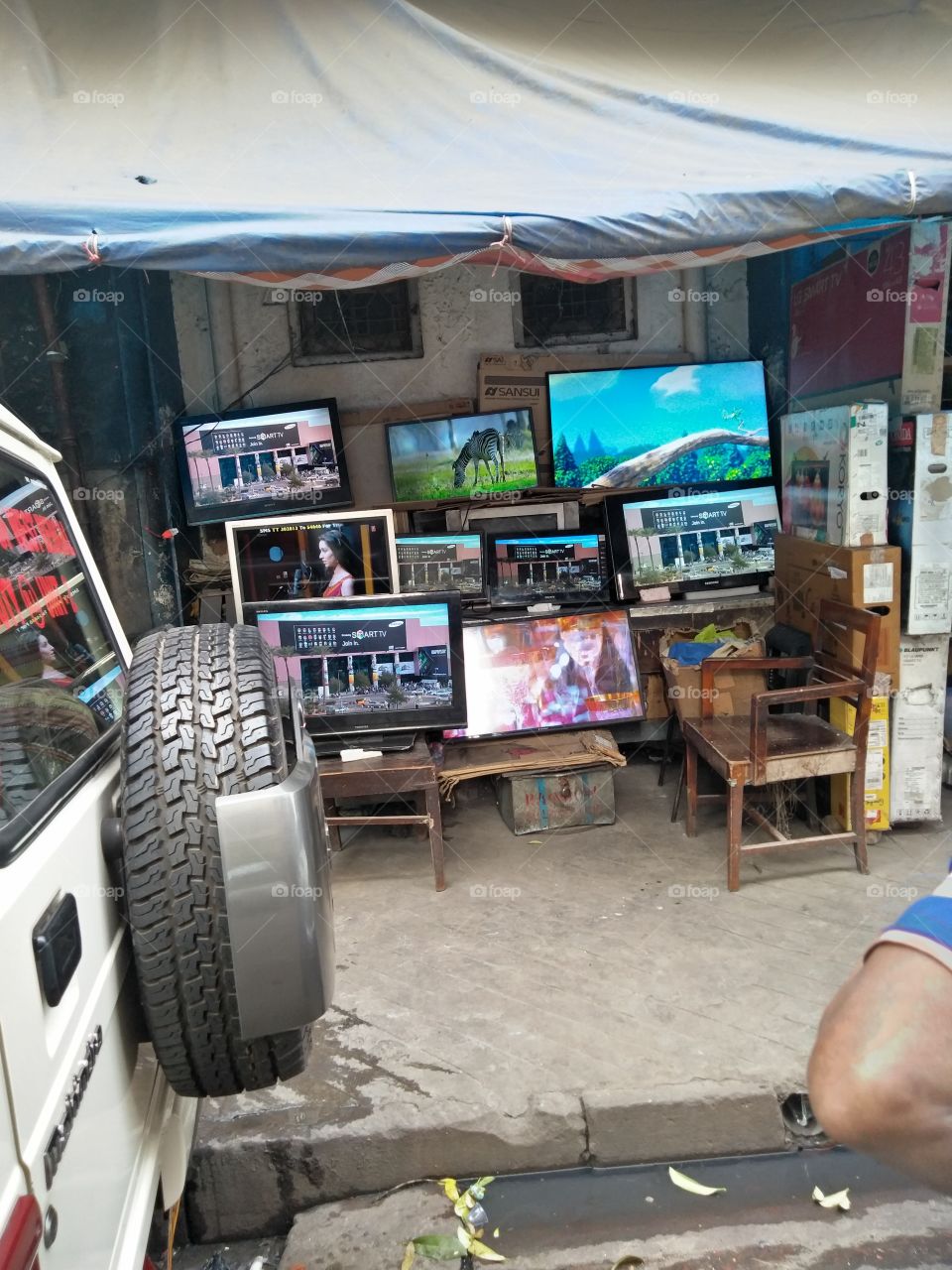 TV monitors on sale on a Chandni Chawk Footpath