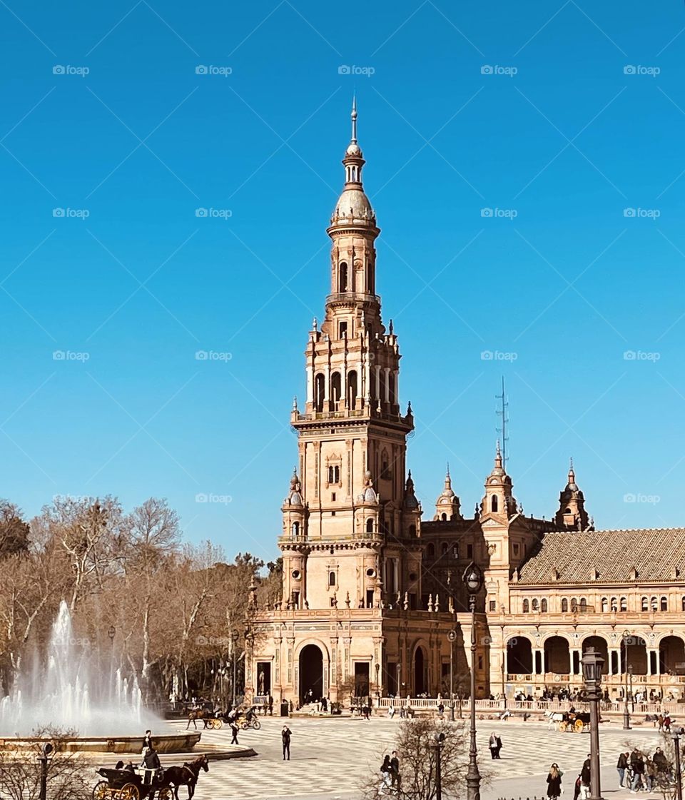 View of Plaza de Espana in Seville with fountain and clear blue sky 