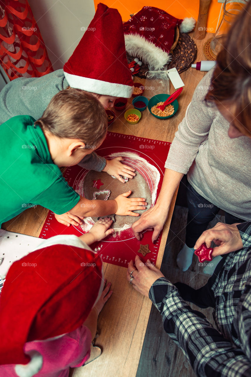 Baking Christmas cookies. Christmas gingerbread cookies in many shapes decorated with colorful frosting, sprinkle, icing, chocolate coating, toppers, put on table. Baking traditional cookies. Family celebrating Christmas. Baking at home
