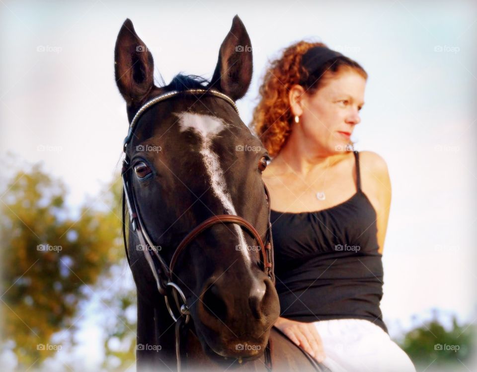 A lady and her horse. A beautiful portrait of a woman on her horse in summer at sunset